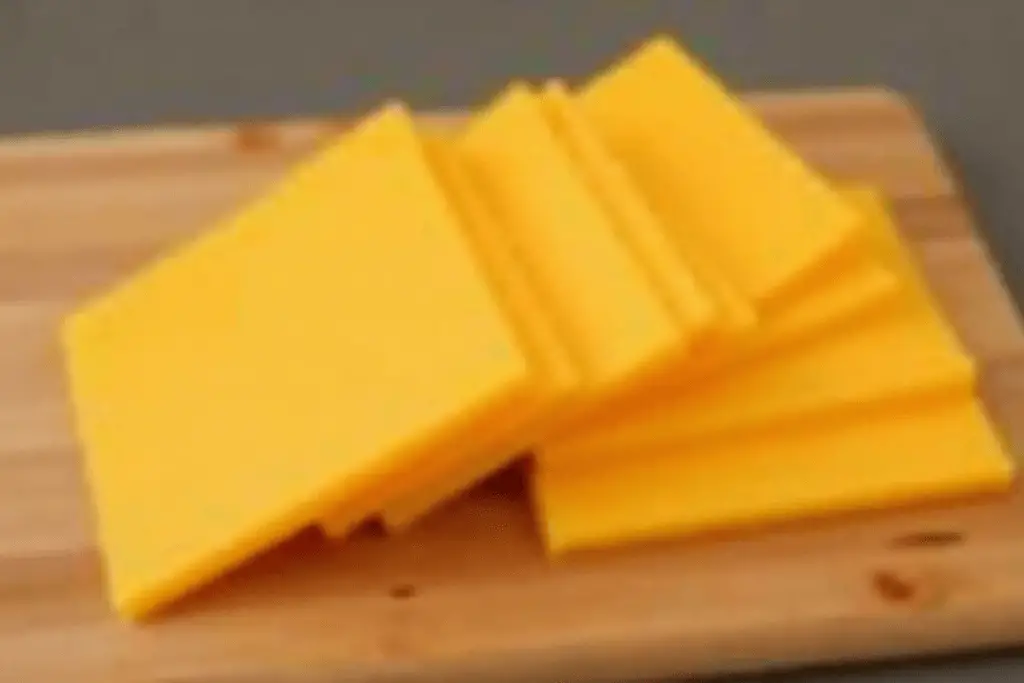 Stacked American cheese slices on a cutting board