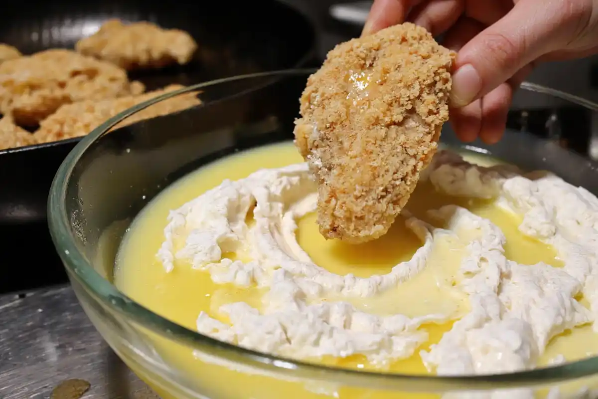 Pam Chicken Nuggets Recall pieces being coated in flour, egg, and breadcrumbs before frying.