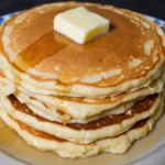 A stack of fluffy homemade pancake Mix with butter and syrup.