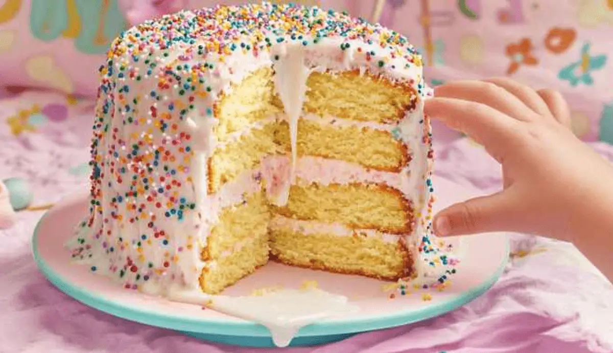 Colorful funfetti-style Sock It To Me Cake topped with sprinkles, perfect for kids.
