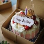Boxed bento cake order with card and birthday candle