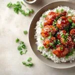 Irresistible sweet chili chicken served with rice and garnished with green onions