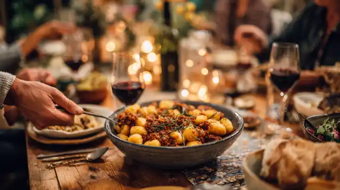 A warm and cozy dinner scene with a large bowl of potato ricotta gnocchi being served at a family table.